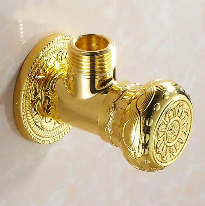 Antique floral brass angle stop valve with golden ornate bathroom faucet featuring intricate scrollwork detailing