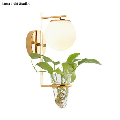 Aplique de pared antiguo dorado/negro con pantalla esférica y cristal crema/gris ahumado, lámpara de pared de una cabeza para dormitorio con maceta de cristal transparente.