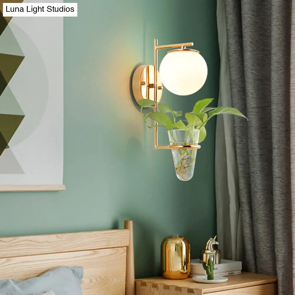 Aplique de pared antiguo dorado/negro con pantalla esférica y cristal crema/gris ahumado, lámpara de pared de una cabeza para dormitorio con maceta de cristal transparente.