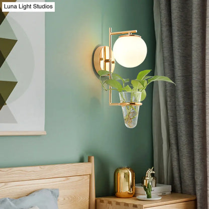 Aplique de pared antiguo dorado/negro con pantalla esférica y cristal crema/gris ahumado, lámpara de pared de una cabeza para dormitorio con maceta de cristal transparente.