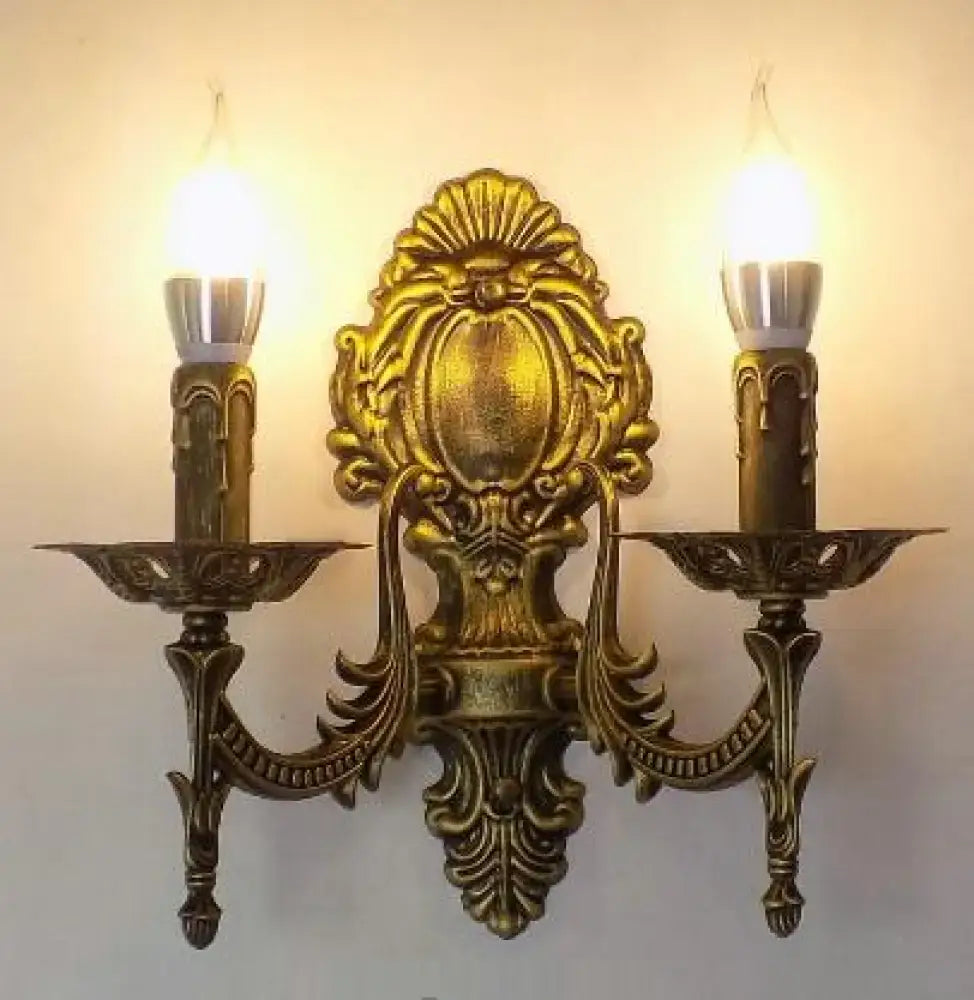 Antique gold retro european wall light ornate sconce with two candle-style lights and intricate baroque detailing