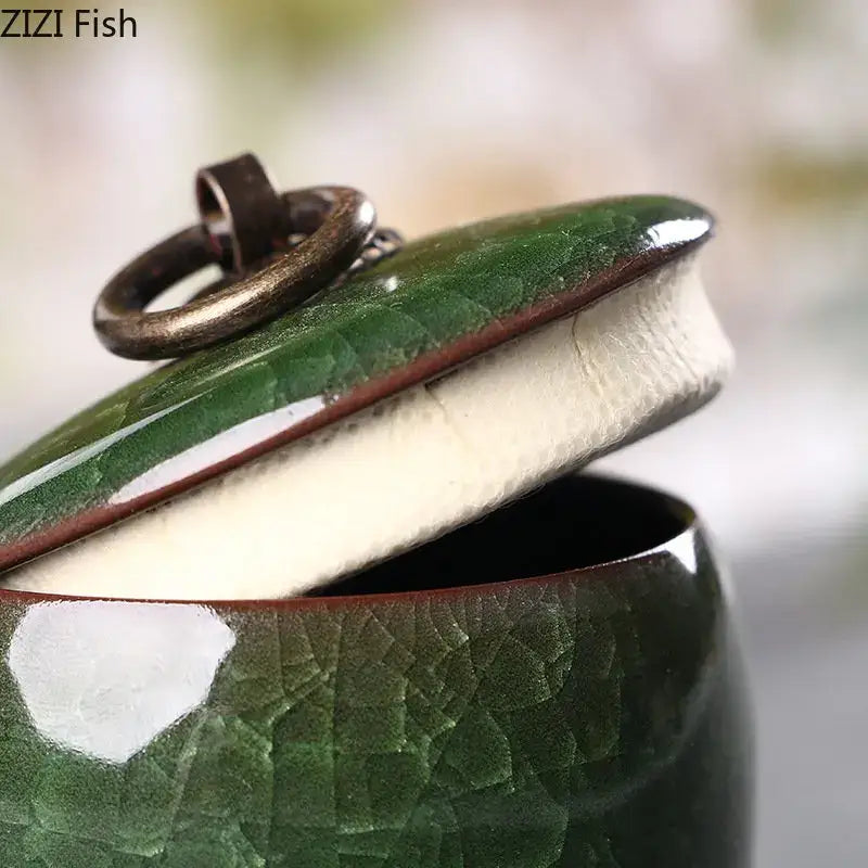 Antique green ceramic tea caddy with ice cracked texture, white interior, and antique brass ring handle for kitchen storage