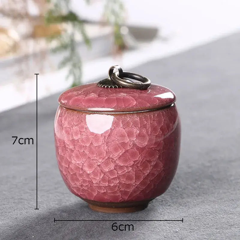 Antique ceramic tea caddy with vibrant pink ice cracked texture glaze and dark metal ring handle for kitchen storage