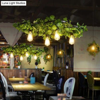 ثريا على شكل عجلة عربة حديدية عتيقة مع ديكور نباتي أخضر - مثالية لإضاءة سقف المطعم