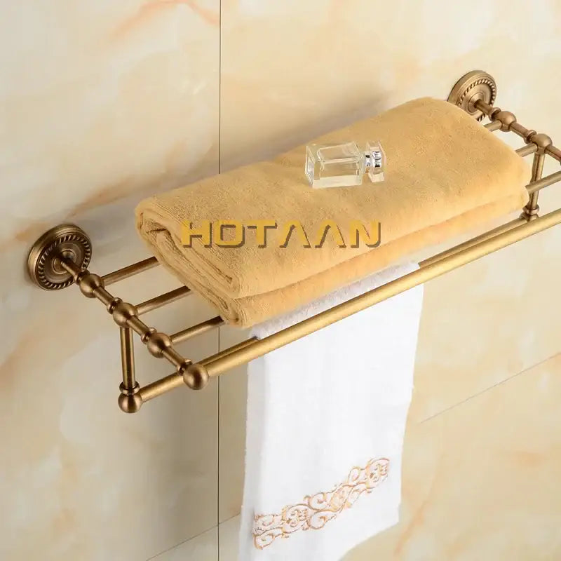 Antique ornate brass towel rack with multi-tiered shelves, spherical finials, and decorative wall mounts by decorbites