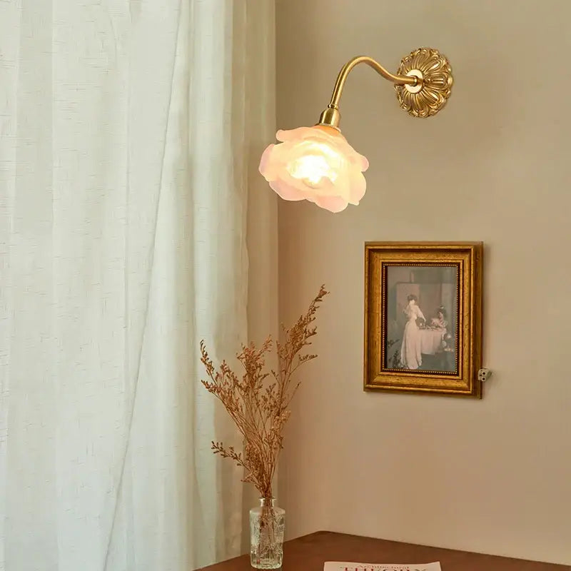 A gold-toned wall lamp with antique pink rose glass shade and decorbites copper arm led for bedroom decor