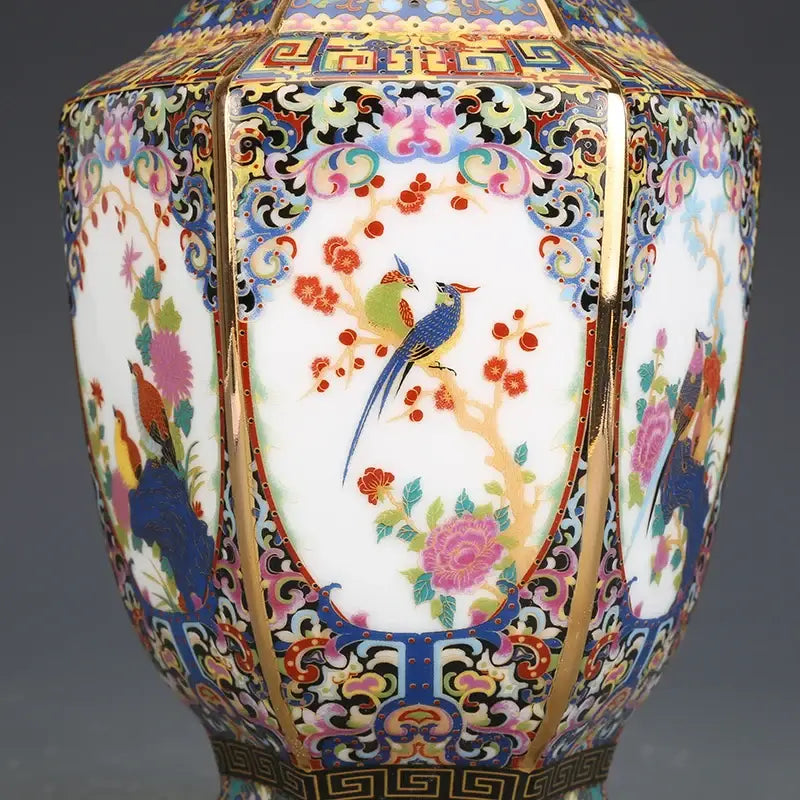 Hexagonal porcelain vase with intricate enamel bird and blossom paintings in vibrant colors with gold trim from vase collection