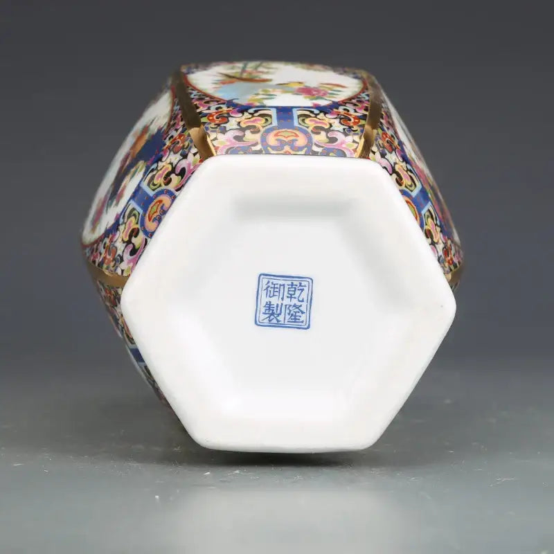 Antique hexagonal porcelain vase with intricate multicolored enamel paintings and gold trim in a porcelain vase collection