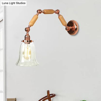 Aplique de pared antiguo en oro rosa con forma acampanada, brazo extensible y cristal transparente.