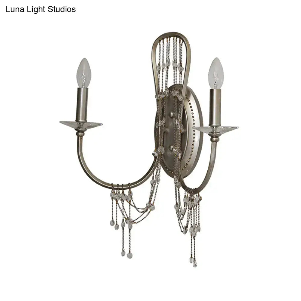 Antique silver crystal wall light sconce with two curved arms and crystal bead chain accents for bedroom use