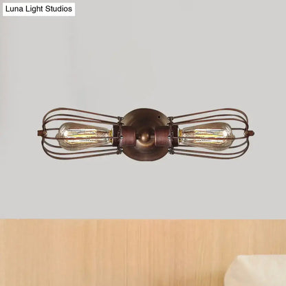 Antique style black bronze sconce light with two exposed edison bulbs in a dark bronze wire cage for dining rooms