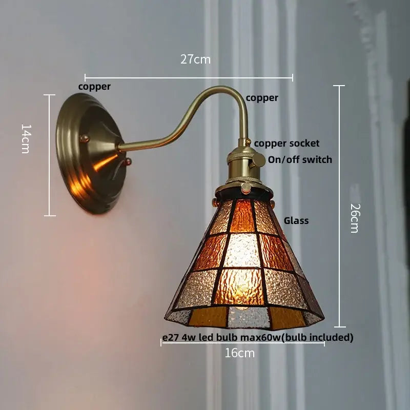 Antique brass-finished copper wall light fixture with stained glass amber and frosted shade for bedroom sconce