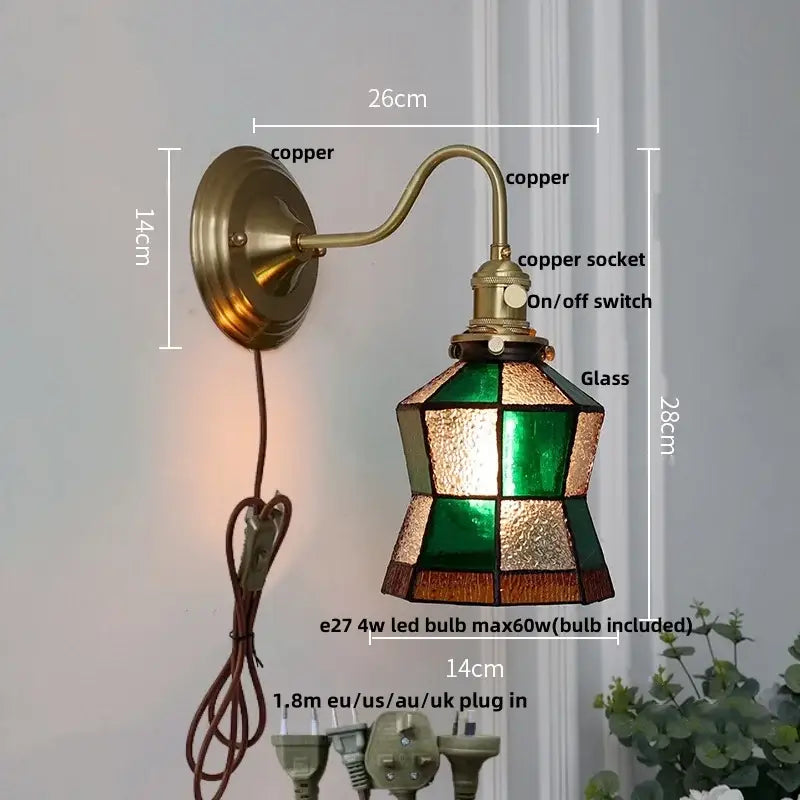Antique copper wall light fixture with a stained glass shade in green amber and brown geometric patterns for bedroom use