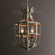Antique wrought iron elegant candle chandelier with ornate leaf motifs and three glowing candle chandelier lights