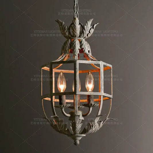 Antique wrought iron elegant candle chandelier with ornate leaf motifs and three glowing candle chandelier lights