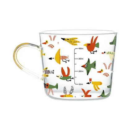 Clear glass 500ml glass mug with yellow handle featuring apricot and orange pattern and colorful cartoon birds