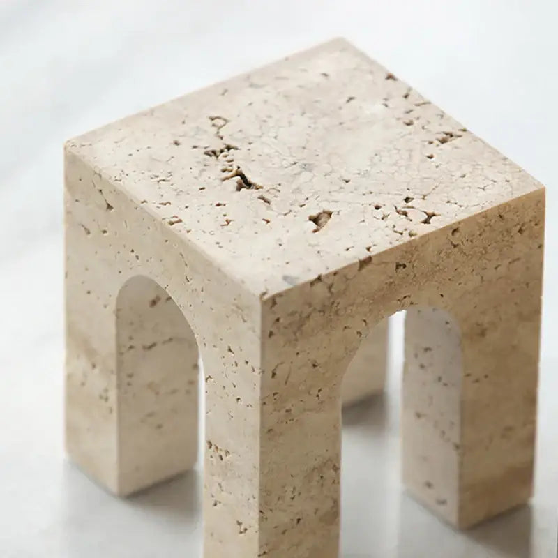 Beige travertine coffee table cabinet with arched openings and natural textured surface for living room use
