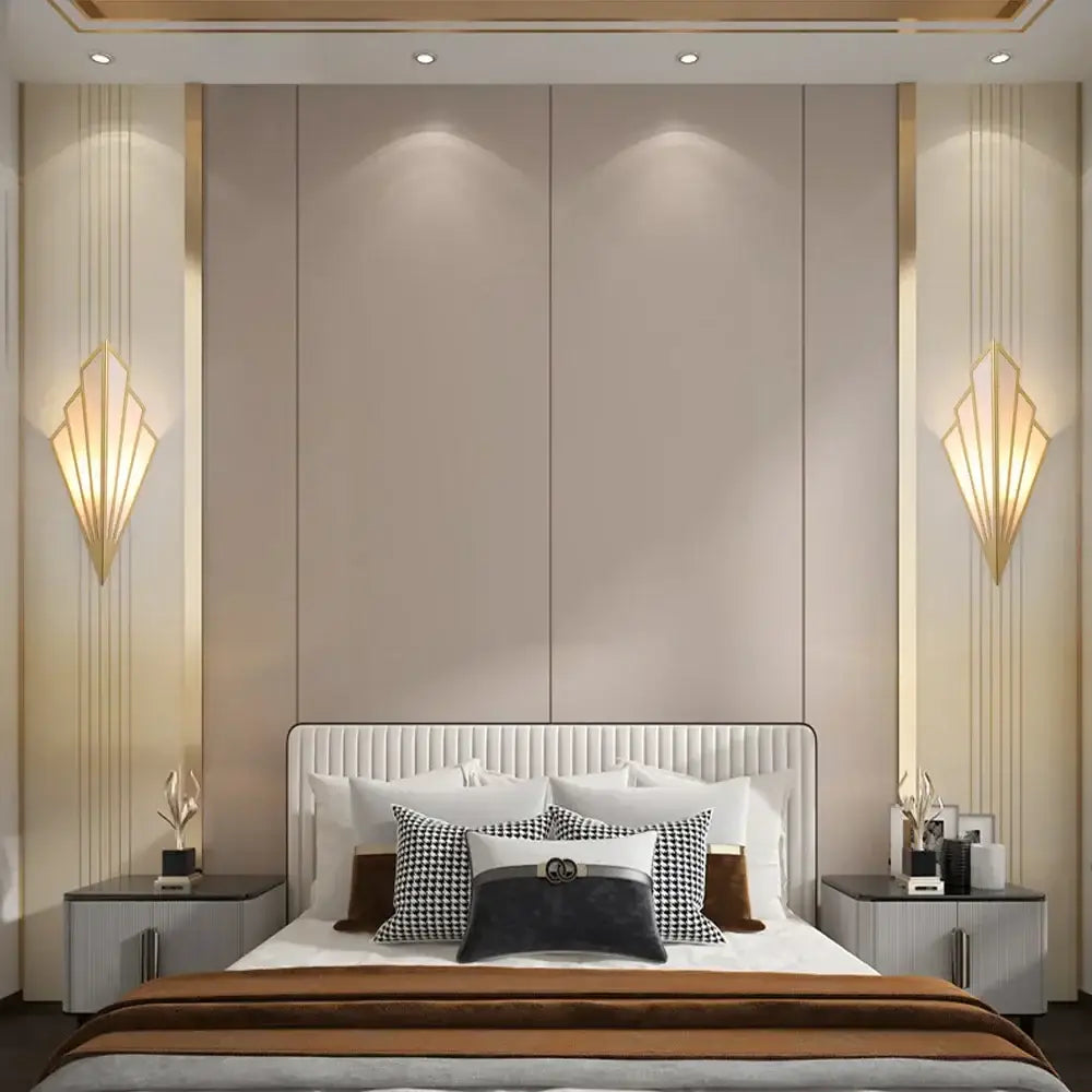 The bed with a white tufted headboard and black white brown pillows features an art deco black and cream led wall lamp