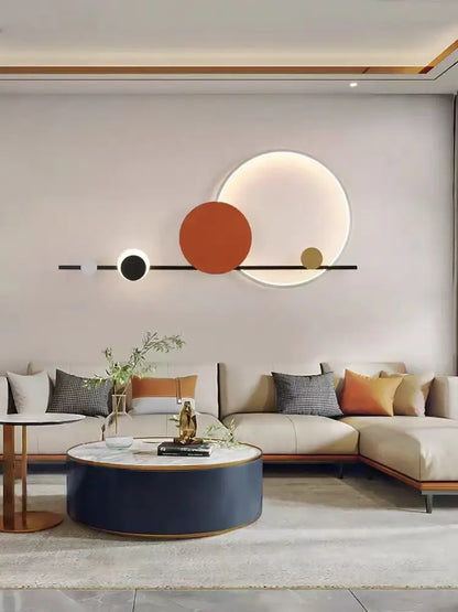 Art deco led wall sconce featuring black orange and gold circular geometric design mounted on light gray wall