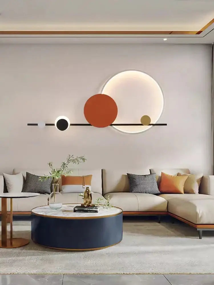 Art deco led wall sconce featuring black orange and gold circular geometric design mounted on light gray wall