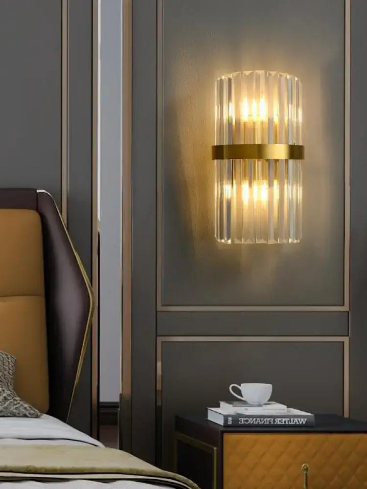 Modern wall sconce with vertical crystal rods and gold-toned metallic band for decorbites art deco stainless design