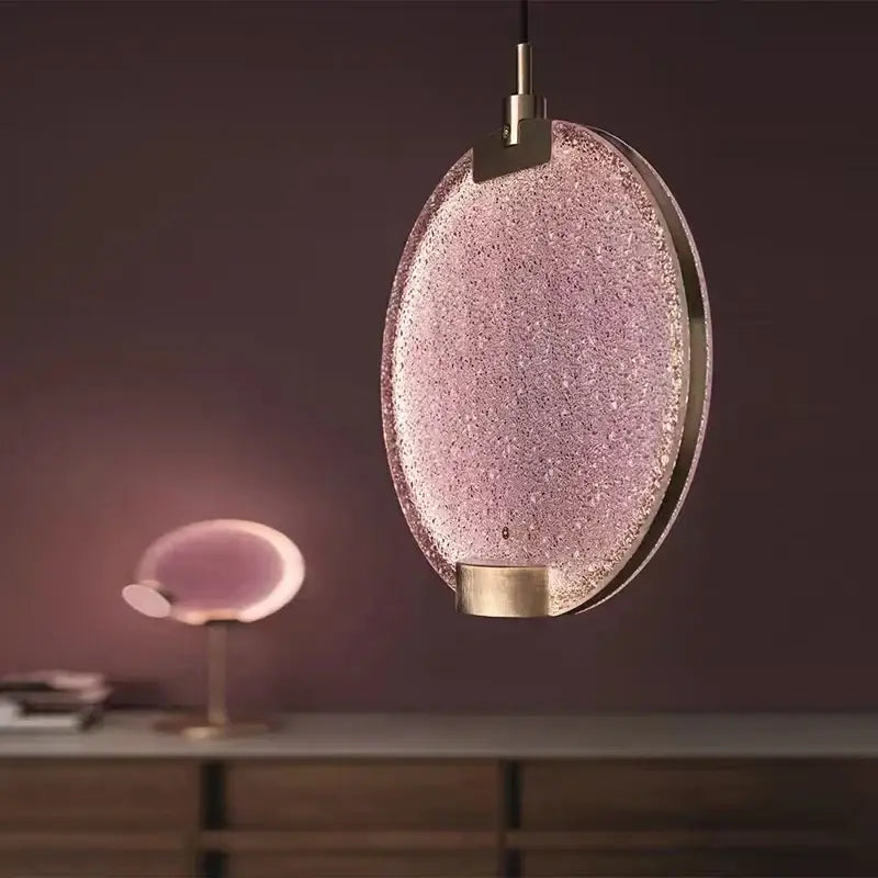 Delicate oval clear pink glass pendant light with textured sparkling shade and polished brass accents by decorbites
