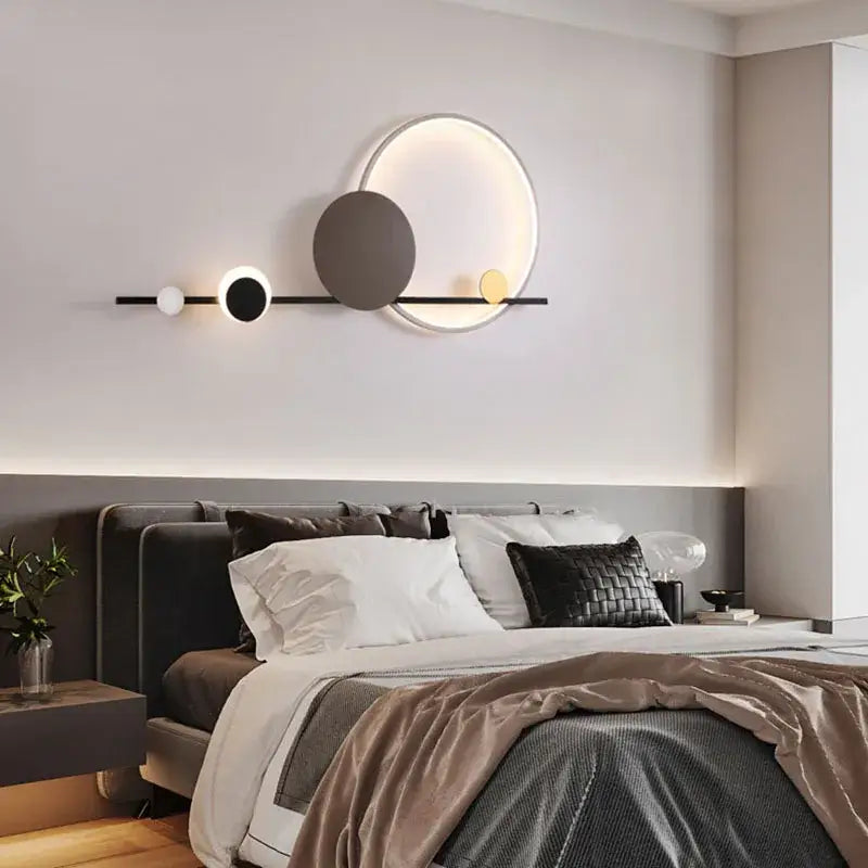Modern circular art deco led wall sconce with black bar and three illuminated white charcoal gray and gold orbs
