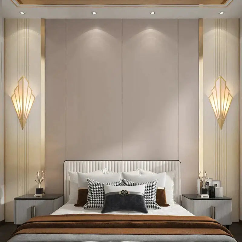 The bed with white tufted headboard and pillows beneath an art deco gold diamond shape modern wall light in bedroom