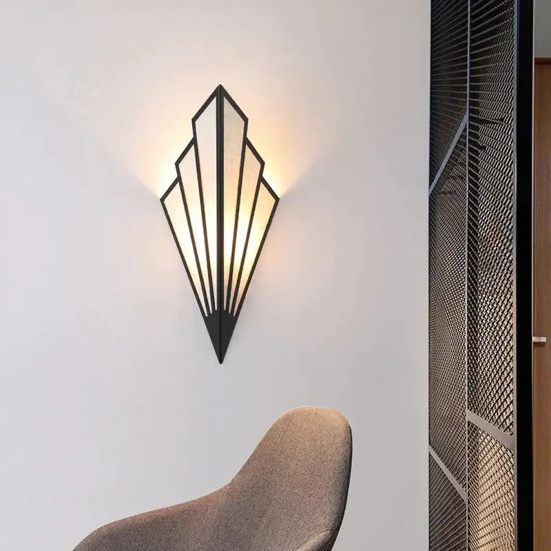 Black metal art deco wall light with diamond shape modern geometric fan design and warm diffused lighting for bedroom