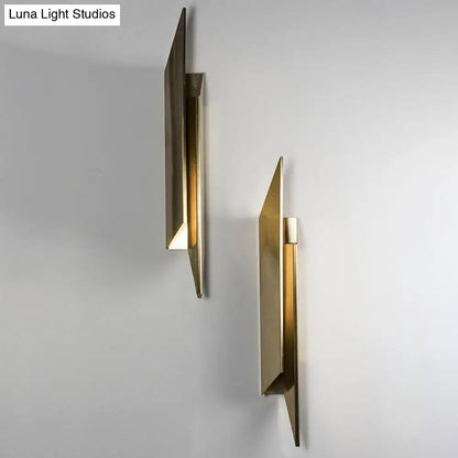 Modern gold-toned art deco wall lamp with geometric design and minimalist metallic finish for bedroom lighting