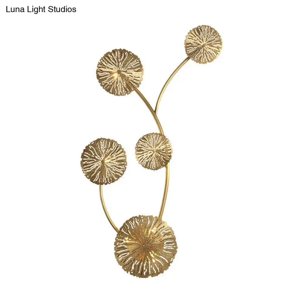 Gold-toned metal art deco wall mount light fixture with five textured circular discs on curved stems for bedroom sconce
