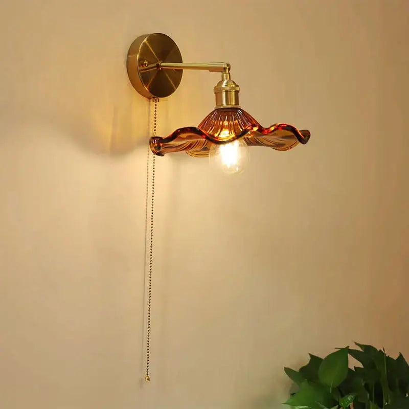 Art deco led wall lamp with brass sconce and amber glass shade shaped like flowing petals by decorbites art deco