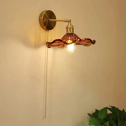 Art deco led wall lamp with brass sconce and amber glass shade shaped like flowing petals by decorbites art deco