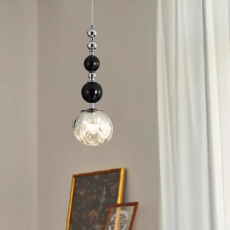 Art deco pendant light with black and chrome beads and textured glass globe for living room square meters lighting