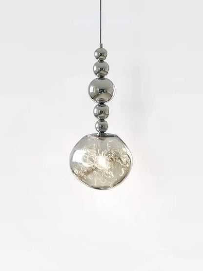 A modern art deco silver pendant light with polished chrome spheres and a textured glass globe for living room