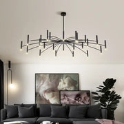 Black metal slender arm art pendant chandelier by decorbites illuminating living room with multiple light bulbs