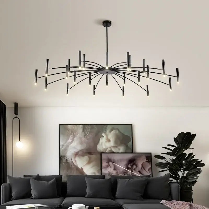 Black metal slender arm art pendant chandelier by decorbites illuminating living room with multiple light bulbs