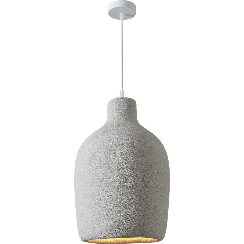 Concrete pendant light with white cord and metal ring, modern design.