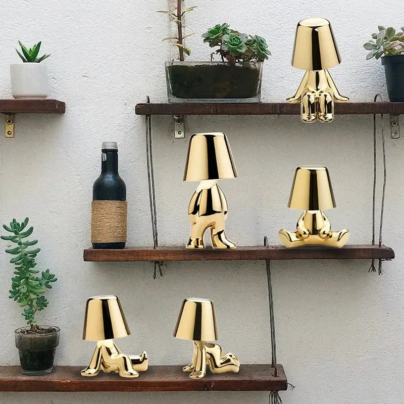 Articulated golden man table lamp with glossy finish and lampshade head used as night light for bedroom decor