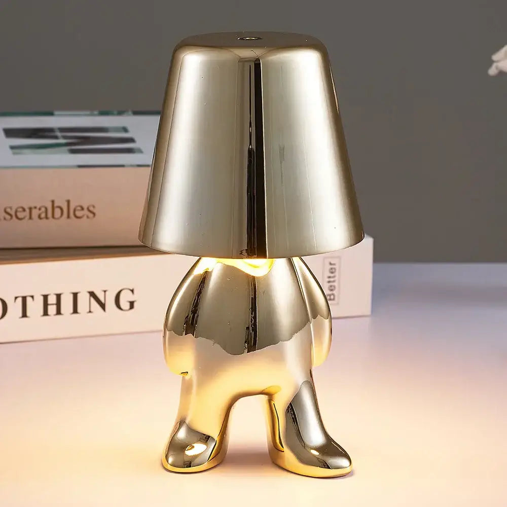 Articulated golden man table lamp made of shiny metallic gold designed as night light for bedroom use