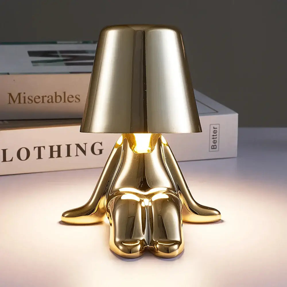 Articulated golden man table lamp with a sleek conical shade providing warm ambient night light for bedroom use
