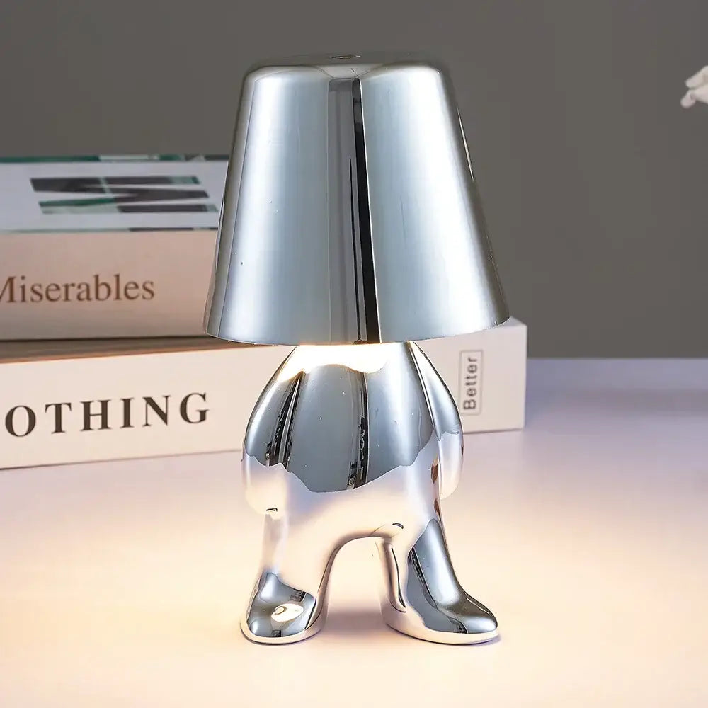 Shiny chrome-plated articulated golden man table lamp with rounded cone head and stylized legs for bedroom night light
