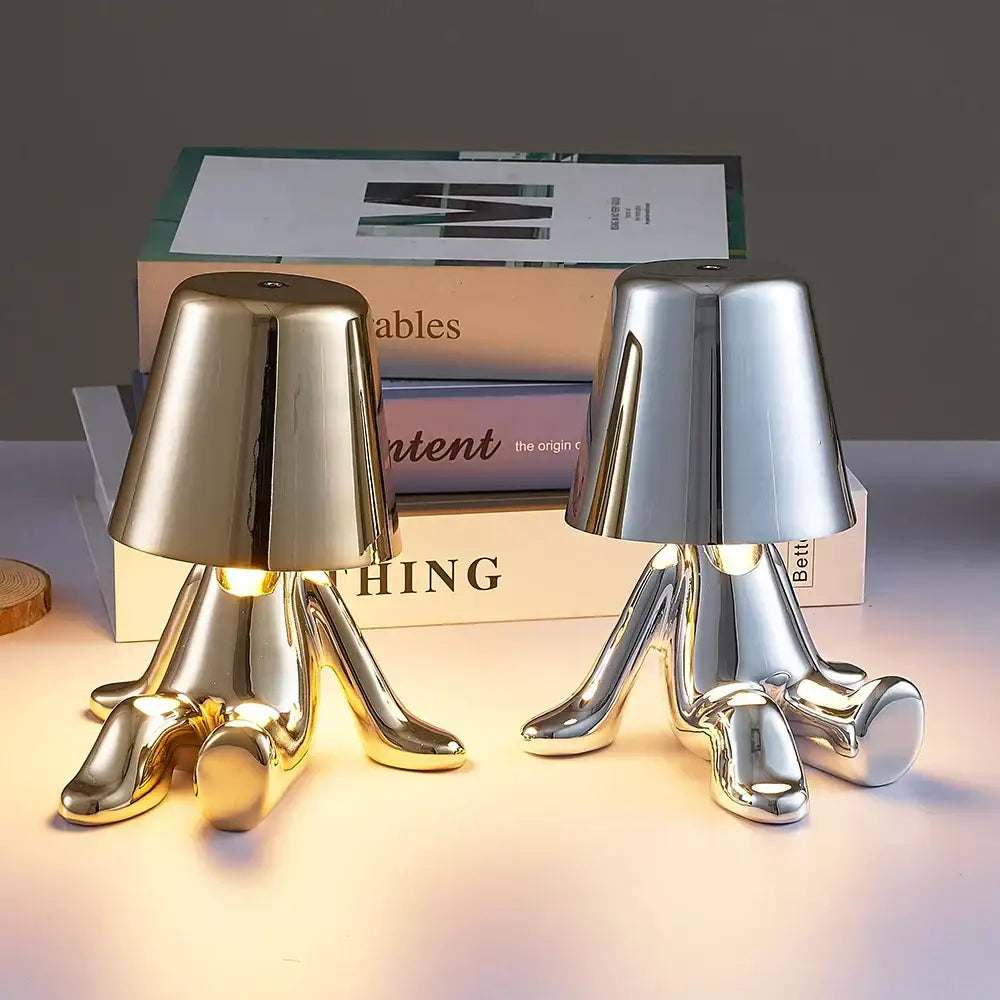 Two sleek metallic man table lamps in gold and silver with polished surfaces designed as night light fixtures