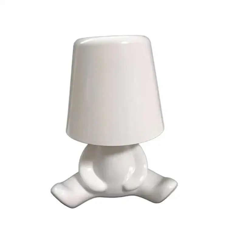 White ceramic night light with rounded minimalist design resembling a seated figure for golden man table lamp