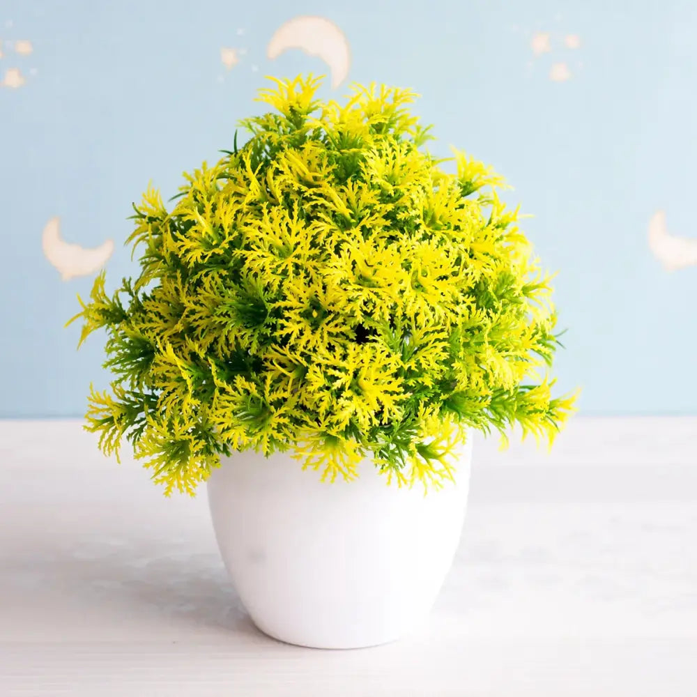 Artificial bonsai tree with vibrant yellow and green feathery foliage in white ceramic pot for garden decor