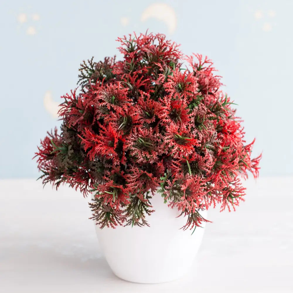 Artificial bonsai tree with vibrant red and green feathery foliage in a white ceramic pot for garden decor