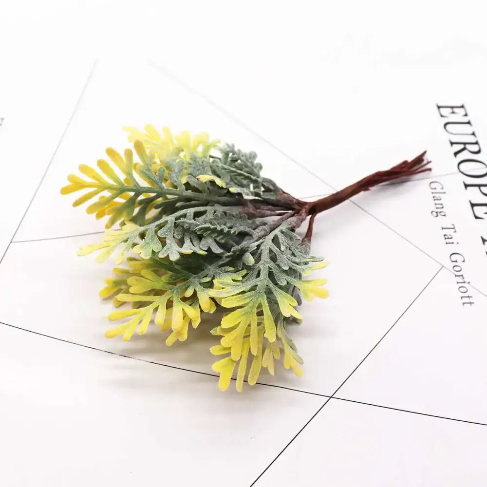 A synthetic foliage sprig with vibrant yellow and muted green leaves made of textured plastic for decorbites green plant flower cherry decor
