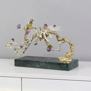 Artisan amethyst and golden tree handicraft featuring a golden bird with purple stones on dark green marble base