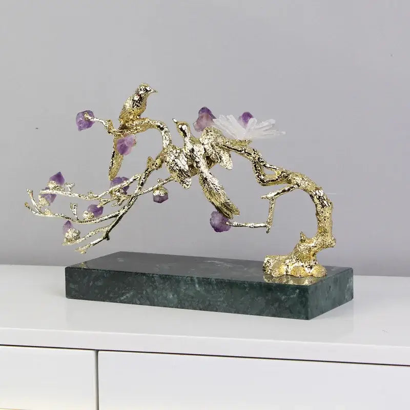 Artisan amethyst and golden tree handicraft featuring a golden bird with purple stones on dark green marble base