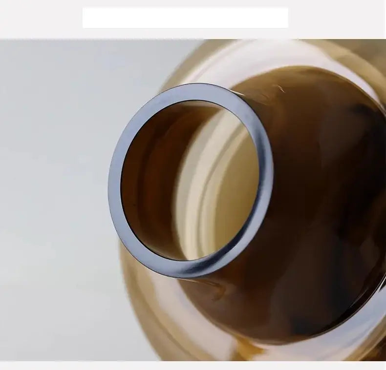 Artisan glass vase featuring amber-colored glass with a sleek metallic silver rim for elegant decor